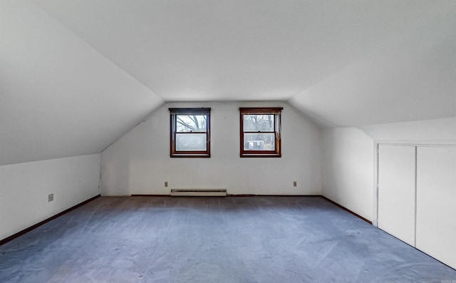 additional living space with carpet floors, a baseboard radiator, and lofted ceiling