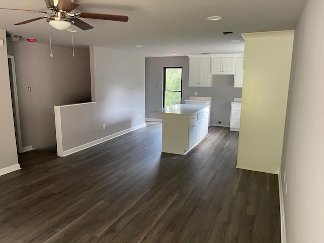 kitchen with a center island, white cabinetry, ceiling fan, and dark wood-type flooring