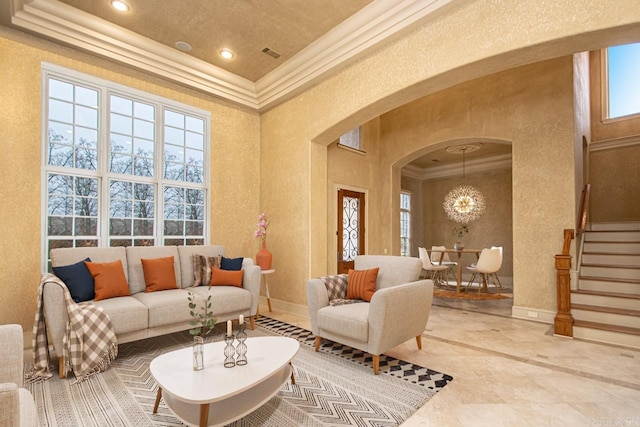 living area with crown molding and an inviting chandelier