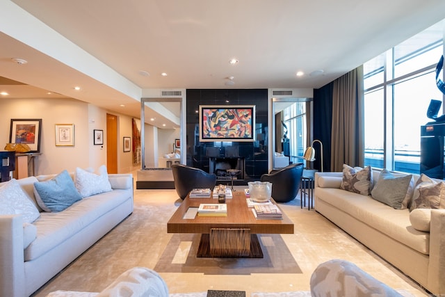 living room with a fireplace and expansive windows