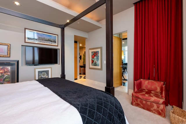 bedroom featuring ensuite bath and light colored carpet