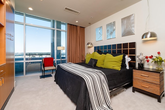 bedroom featuring light carpet and expansive windows