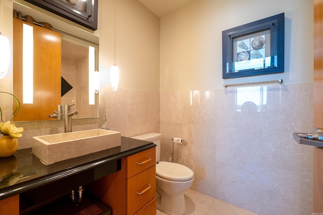 bathroom featuring tile patterned flooring, vanity, tile walls, and toilet