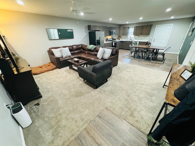 living room featuring light hardwood / wood-style flooring and ceiling fan