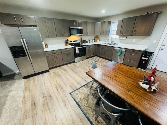 kitchen featuring dark brown cabinets, light hardwood / wood-style floors, sink, and stainless steel appliances