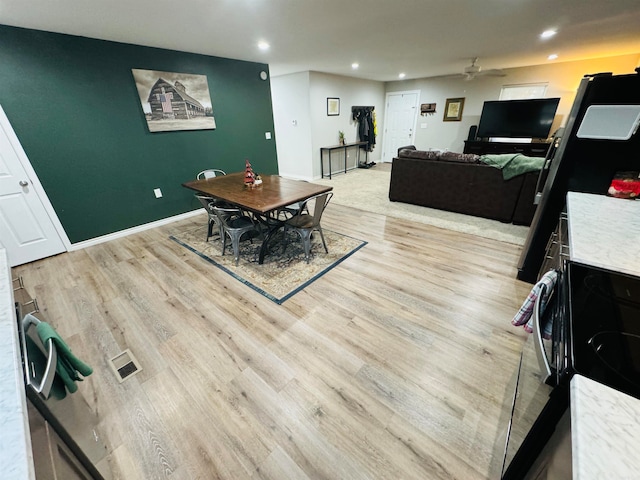 dining space with ceiling fan and light hardwood / wood-style floors