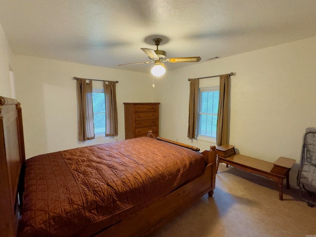 bedroom with carpet, ceiling fan, and multiple windows