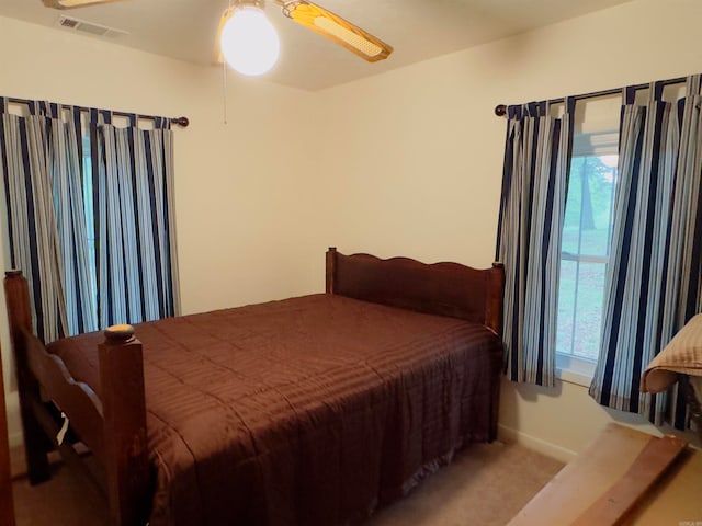 carpeted bedroom with ceiling fan and multiple windows