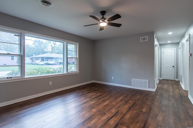 unfurnished room with ceiling fan, dark wood-type flooring, and a wealth of natural light