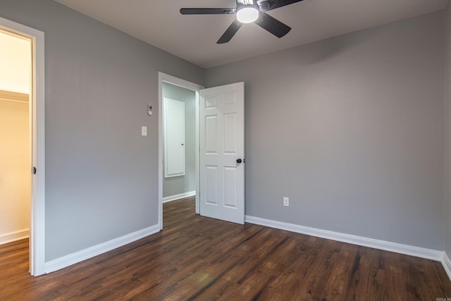 unfurnished bedroom featuring dark hardwood / wood-style floors, a spacious closet, and ceiling fan