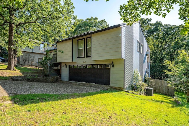 view of front facade featuring central AC unit, a garage, and a front lawn