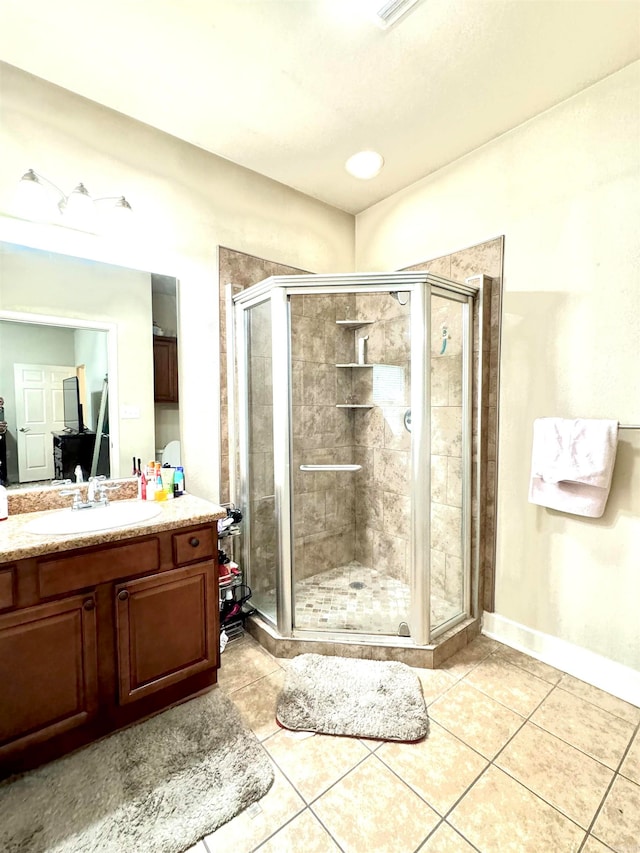 bathroom with tile patterned flooring, vanity, and a shower with door