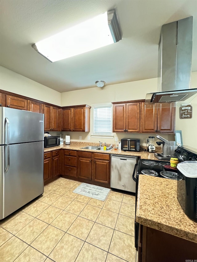 kitchen with light stone countertops, sink, island range hood, light tile patterned flooring, and appliances with stainless steel finishes