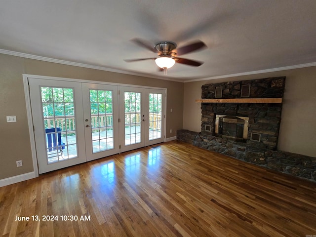 unfurnished living room with wood-type flooring, ornamental molding, a wealth of natural light, and french doors