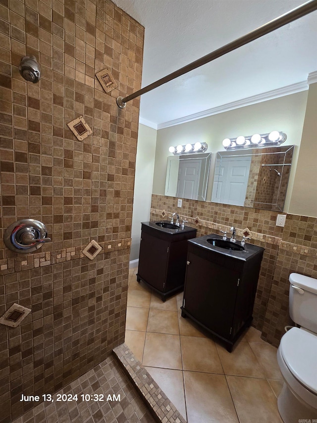 bathroom with vanity, crown molding, tile patterned flooring, toilet, and tile walls