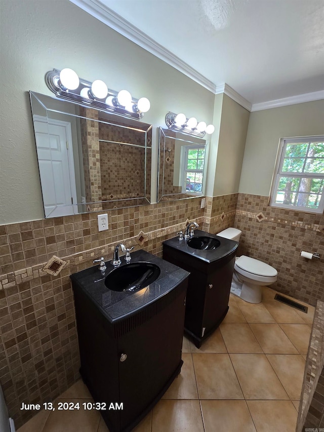 bathroom featuring tile patterned flooring, plenty of natural light, ornamental molding, and vanity