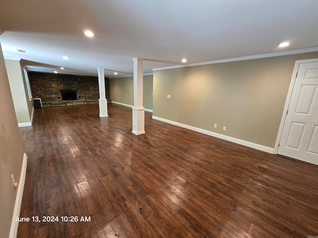 basement featuring a fireplace, ornamental molding, and dark wood-type flooring