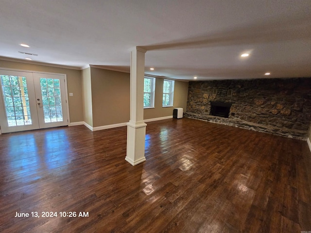 unfurnished living room featuring dark hardwood / wood-style flooring, a fireplace, and a wealth of natural light