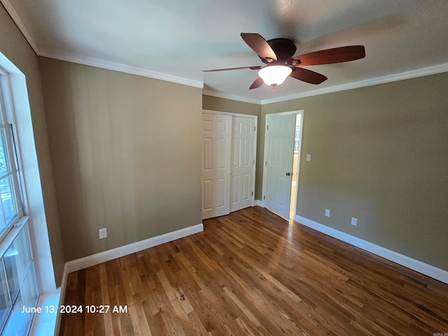 unfurnished bedroom featuring wood-type flooring, a closet, ceiling fan, and crown molding