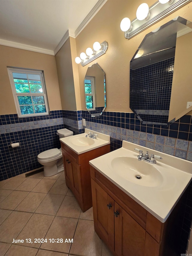 bathroom with vanity, tile patterned floors, crown molding, toilet, and tile walls