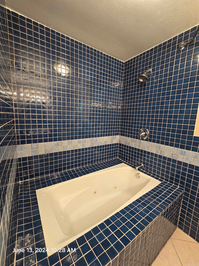 bathroom with tile patterned floors, tiled shower / bath combo, tile walls, and a textured ceiling