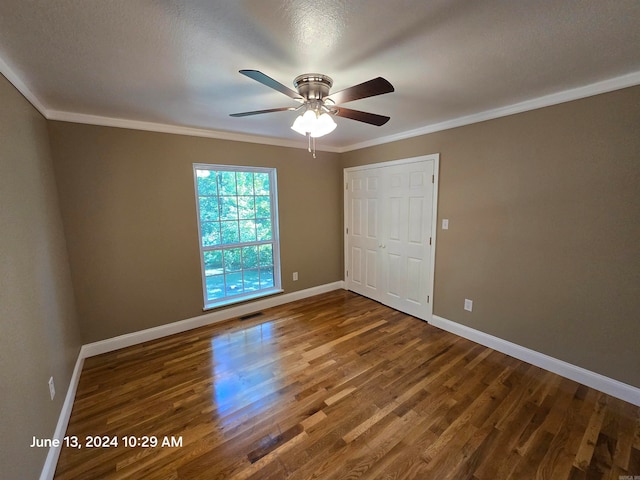 interior space with ceiling fan, dark hardwood / wood-style floors, a textured ceiling, a closet, and ornamental molding