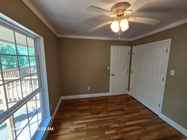 unfurnished bedroom with a closet, ceiling fan, dark hardwood / wood-style flooring, and ornamental molding