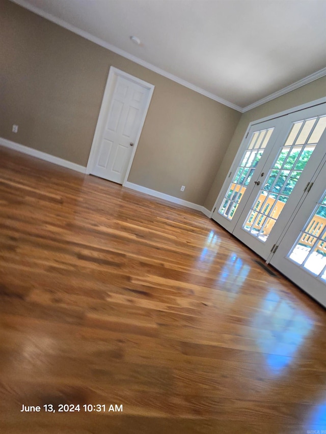 unfurnished room featuring crown molding, dark wood-type flooring, and french doors