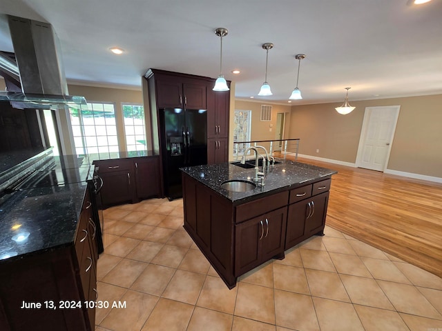 kitchen with pendant lighting, a center island with sink, sink, light hardwood / wood-style floors, and black fridge with ice dispenser