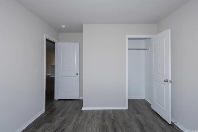 unfurnished bedroom featuring dark wood-type flooring and a closet