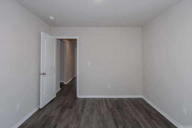 empty room with dark hardwood / wood-style flooring