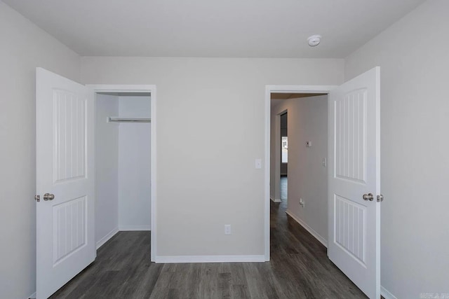 unfurnished bedroom featuring a closet and dark hardwood / wood-style flooring