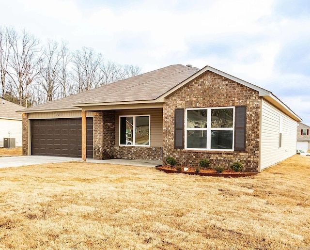 view of front of property with a garage, central air condition unit, and a front yard