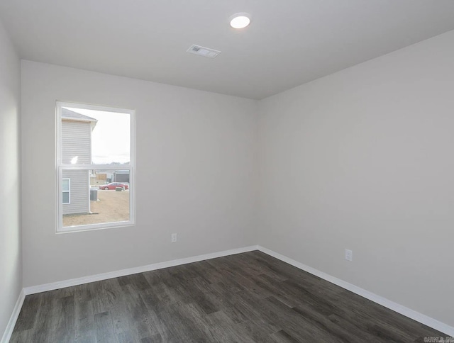 spare room with dark wood-type flooring