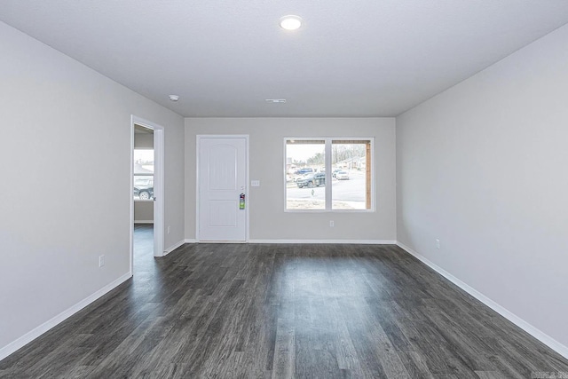 empty room with dark hardwood / wood-style flooring