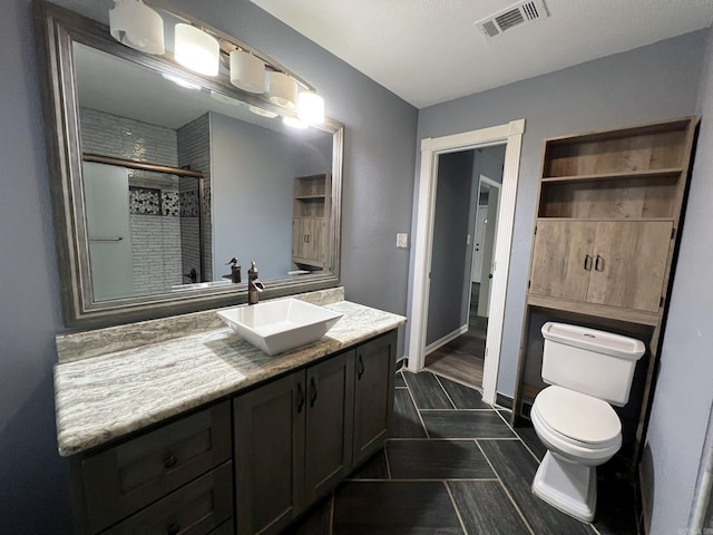 bathroom with tile patterned flooring, vanity, toilet, and an enclosed shower