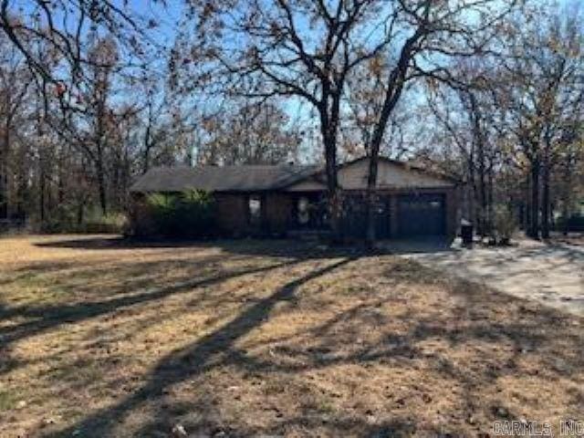 view of front of home featuring dirt driveway and an attached garage