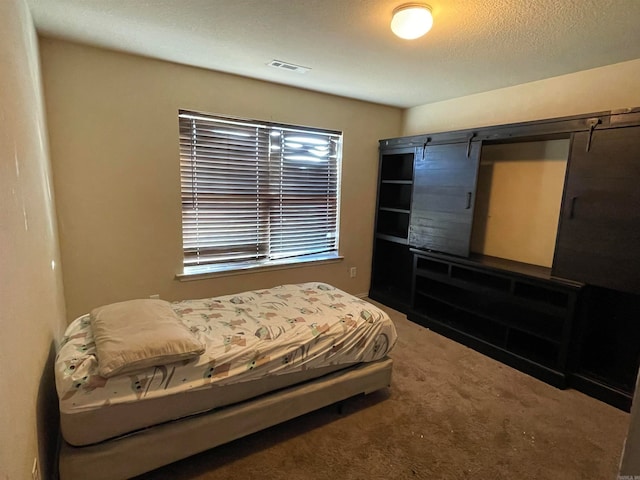 carpeted bedroom featuring a textured ceiling