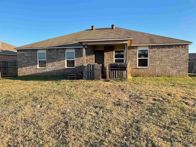 back of house featuring a lawn