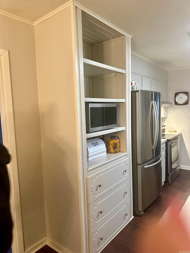 kitchen with a textured ceiling, crown molding, dark wood-type flooring, and appliances with stainless steel finishes