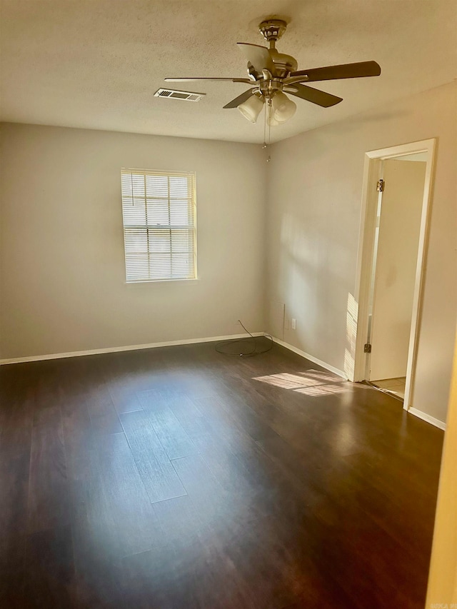 spare room featuring ceiling fan, dark hardwood / wood-style flooring, and a textured ceiling