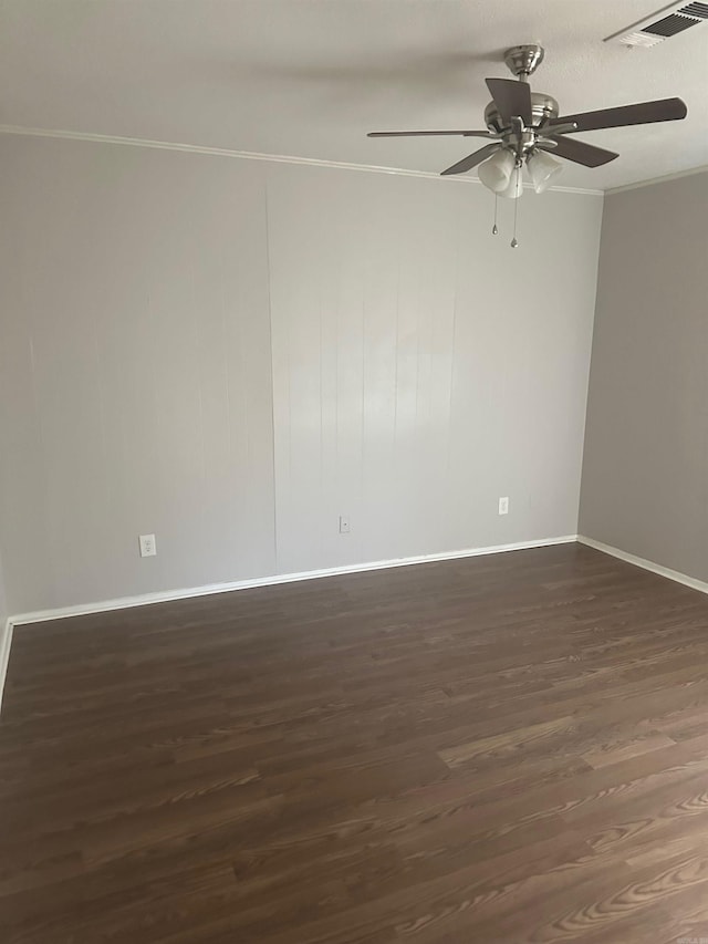 empty room with ceiling fan, crown molding, and dark wood-type flooring