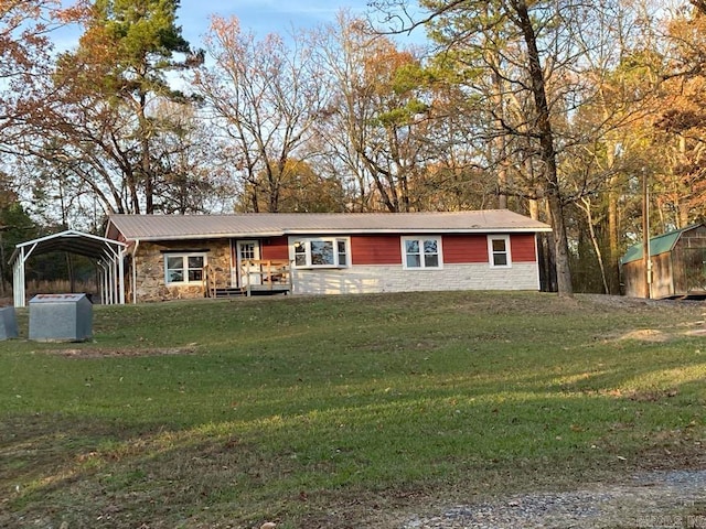 ranch-style home featuring a storage shed, a front lawn, and a carport