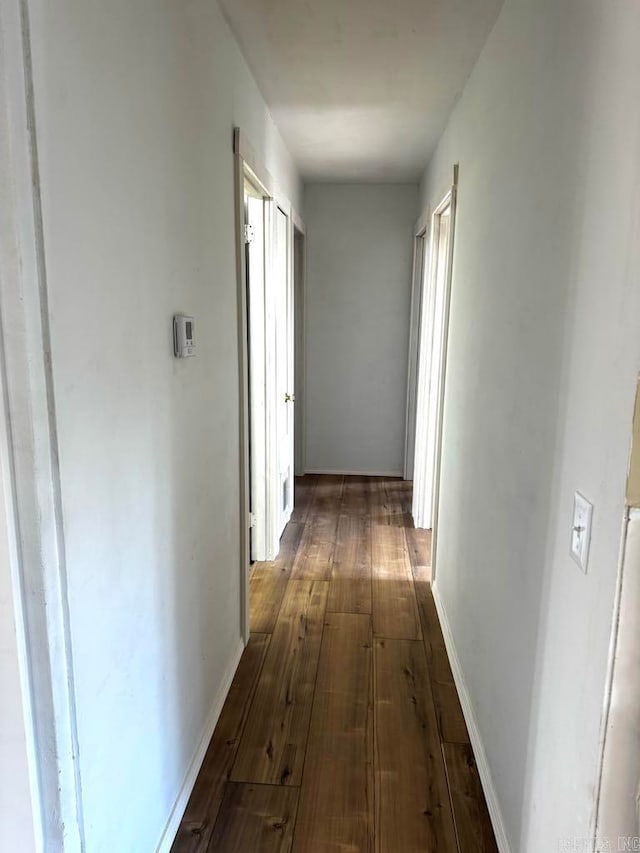 corridor with dark hardwood / wood-style flooring