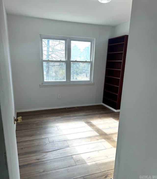 unfurnished room with hardwood / wood-style floors