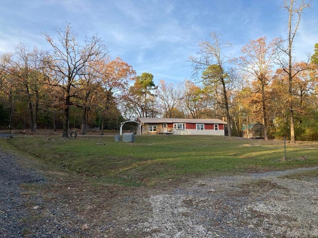 view of front of house featuring a carport, an outdoor structure, and a front lawn