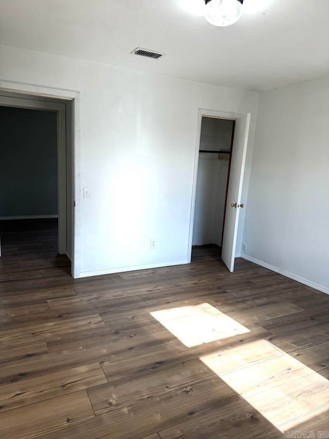 unfurnished bedroom featuring dark wood-type flooring and a closet