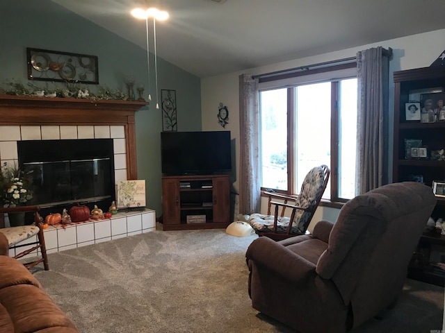 carpeted living room featuring lofted ceiling and a tiled fireplace