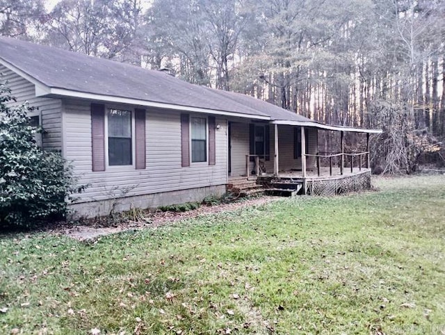 ranch-style home featuring covered porch and a front yard