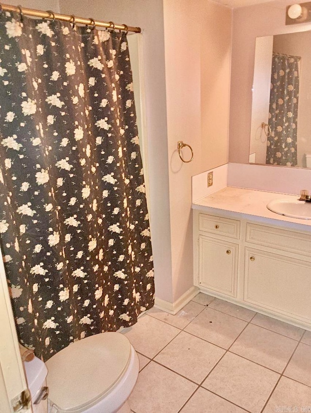 bathroom with toilet, vanity, and tile patterned floors